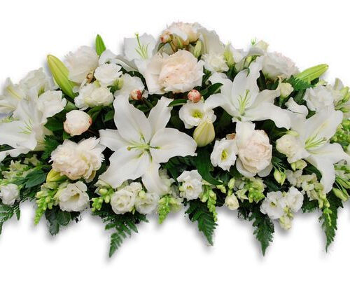 Blomsterarrangemang med vita liljor, rosor och gröna blad, utformat som en kistdekoration